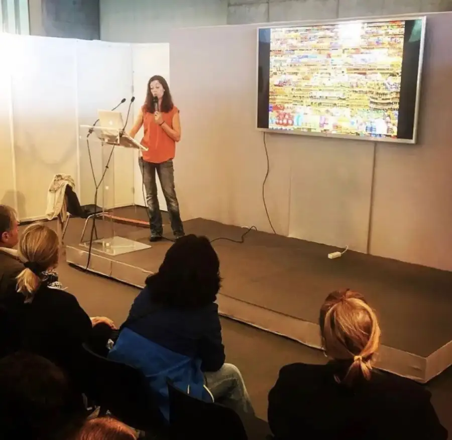 Frédérique Barral en conférence devant un public, face à un écran